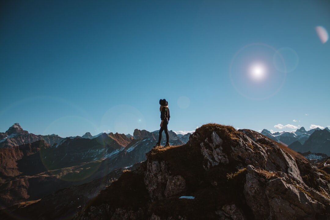 person climbing mountain at dawn