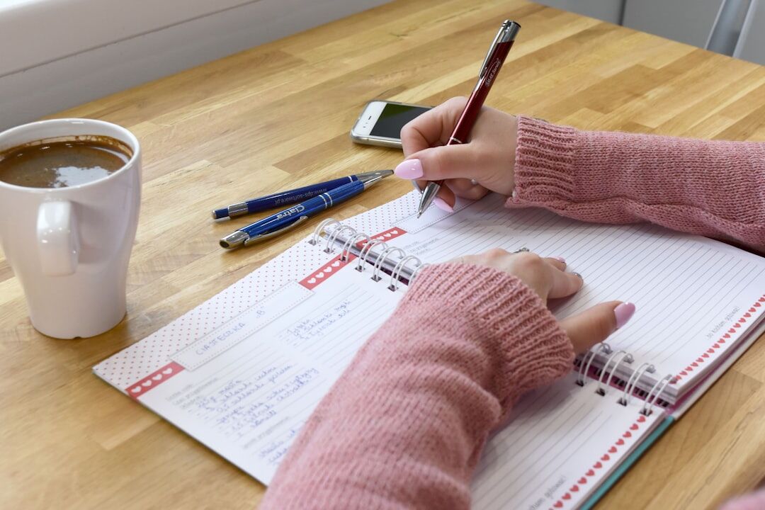 person writing goals in notebook